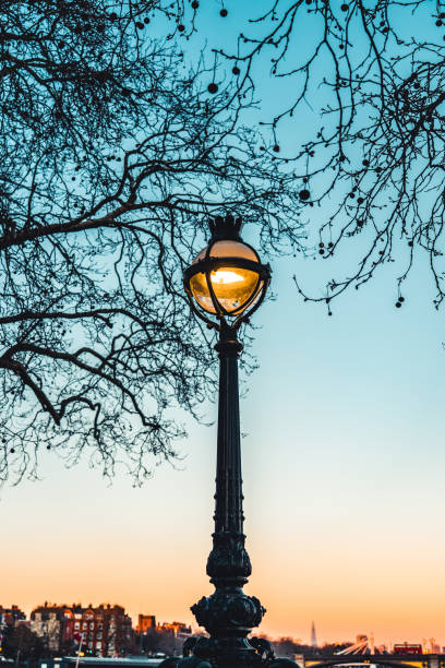 istock Old vintage lantern lamp post on the sunset sky background 1418436823
