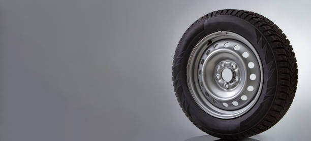 istock Car wheel and winter studded tire on white 1418445155