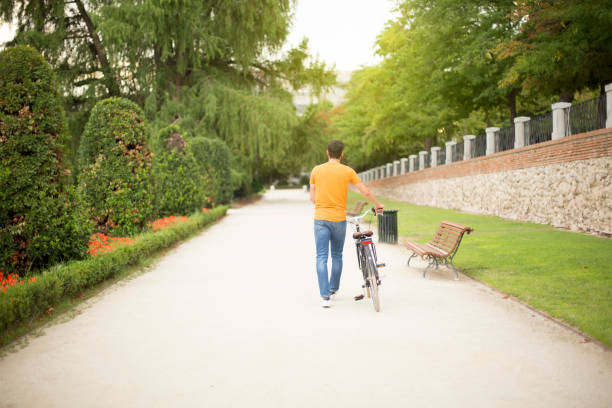Asian man on bicyle early morning in sunny park. Man in motion blurr