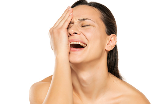a desperate crying young woman on a white background