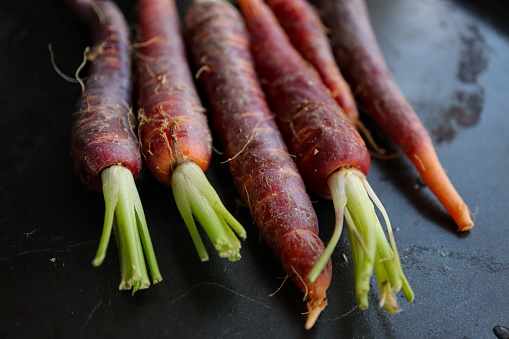 Red baby carrots on a dark background
