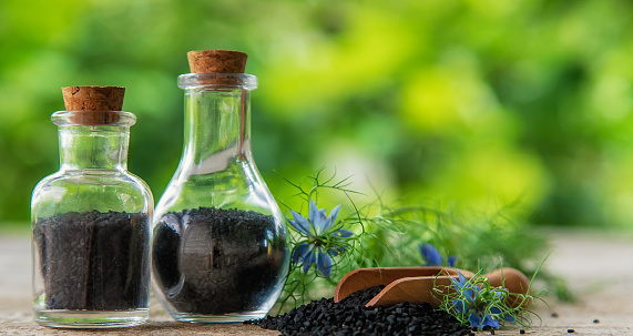 Black cumin oil in a bottle. Selective focus. Nature.