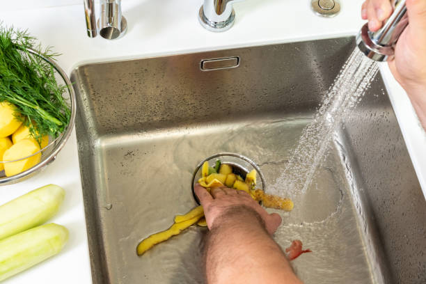 istock A man destroys food waste with a disposal 1418459526