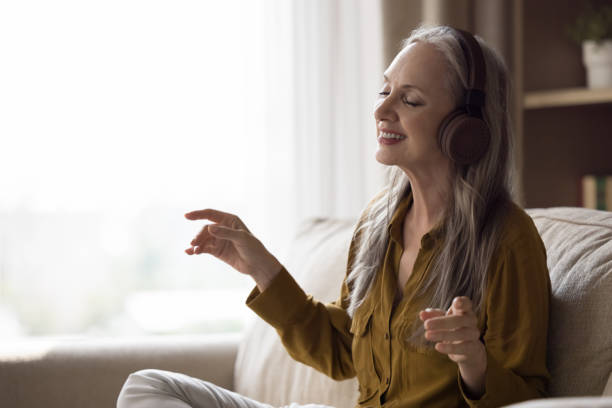 istock Happy joyful beautiful elderly lady in modern headphones having fun 1418459826