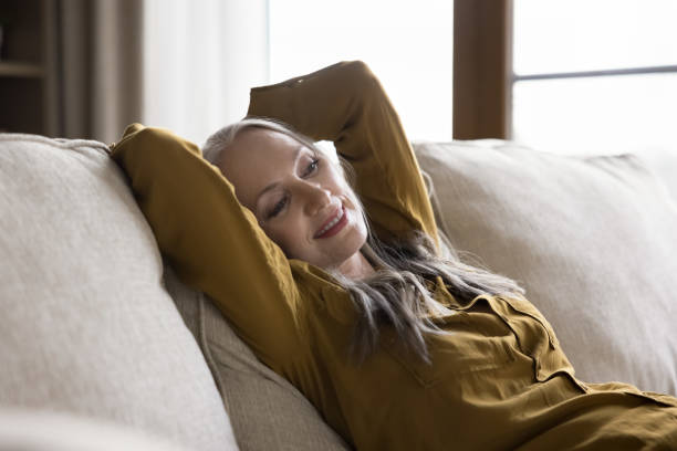 istock Happy relaxed beautiful mature woman resting on home sofa 1418459842