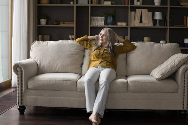 istock Thoughtful peaceful pretty elderly woman resting on soft couch 1418459851