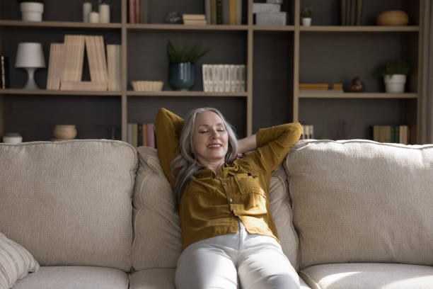 istock Cheerful relaxed mature woman resting on comfortable couch 1418459854
