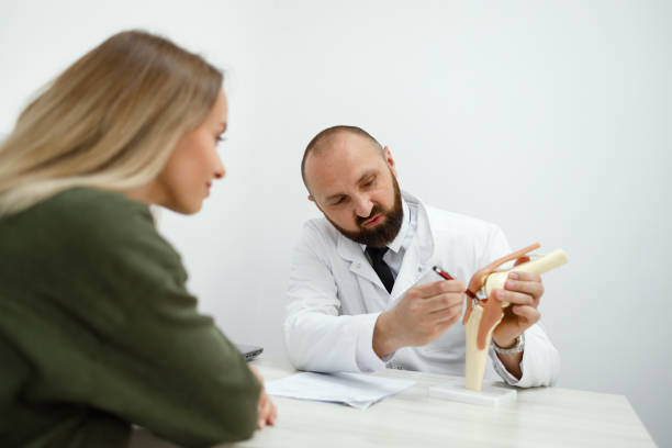 istock Doctor explains the essence of the patient's problem using the example of an artificial model of the knee joint 1418461089