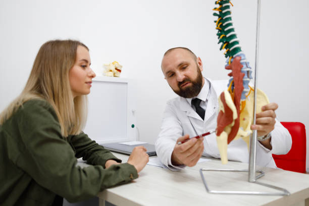 istock Doctor showing spine model to patient 1418461349