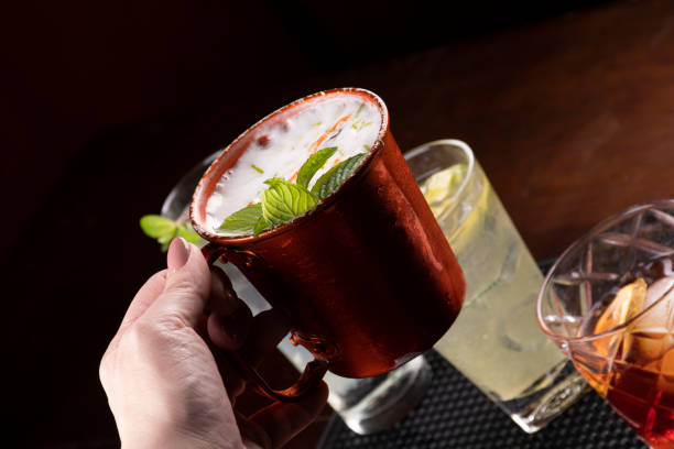 istock holding a moscow mule cocktail in snake mug with blurred drinks in the background 1418467392