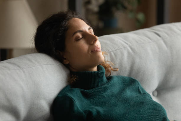 istock Relaxed young happy pretty woman napping on sofa. 1418467538