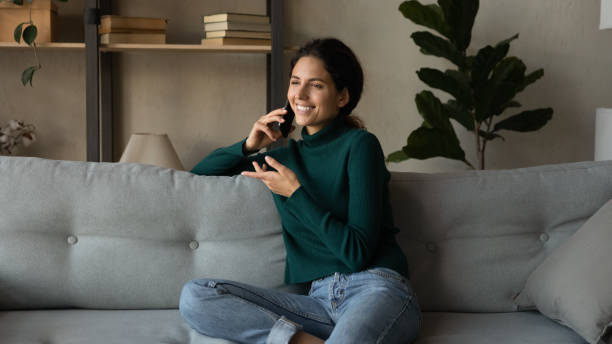 istock Smiling beautiful young woman holding phone call conversation. 1418467543