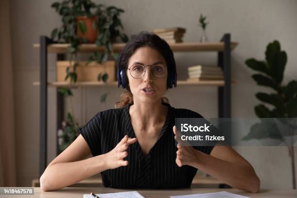 Concentrated Skilled Young Businesswoman Holding Distant Video Call Meeting Stock Photo - Download Image Now