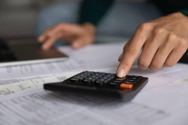 istock Close up young woman using calculator, managing budget. 1418467635