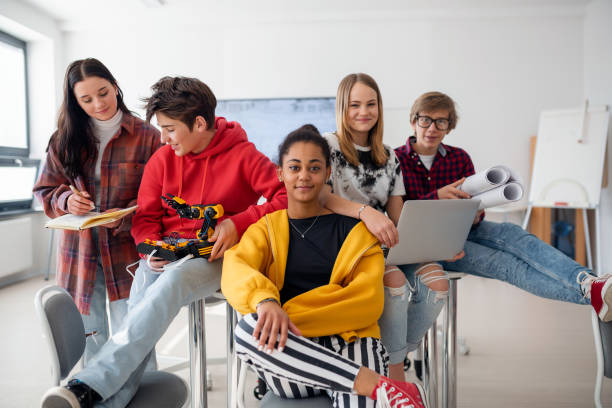 istock Group of students sitting and posing together in robotics classroom 1418467643