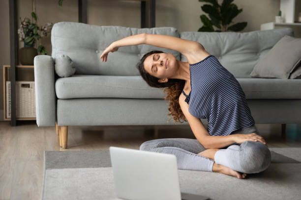 istock Peaceful happy woman practicing yoga exercises at home. 1418471375