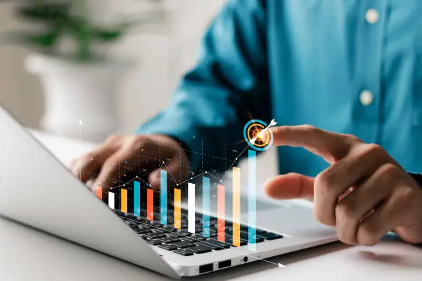 Businessman analyzing company's financial balance sheet working with digital augmented reality graphics. Businessman calculates financial data for long-term investment.