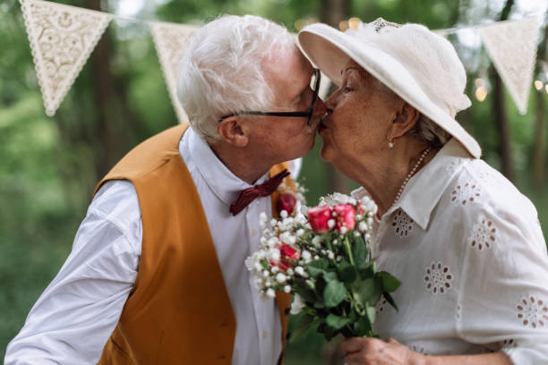 Senior couple having marriage, kissing in nature during summer day. stock photo