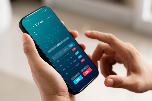 Businessmen work with stock market investments using smartphone to analyze trading data. smartphone with stock exchange graph on screen. Financial stock market.
