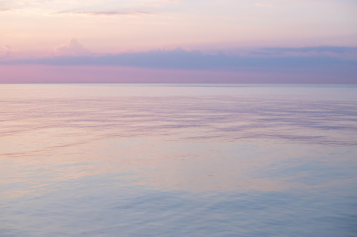 Blurred background sea and sky at sunrise. The sea and the sky are pearly. Beautiful backdrop for your design.