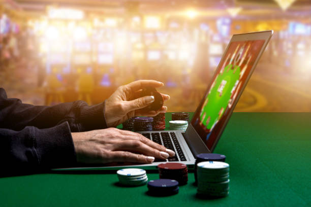istock Woman hands with Gambling Chips using laptop for playing online casino. Concept virtual leisure activity. 1418485855