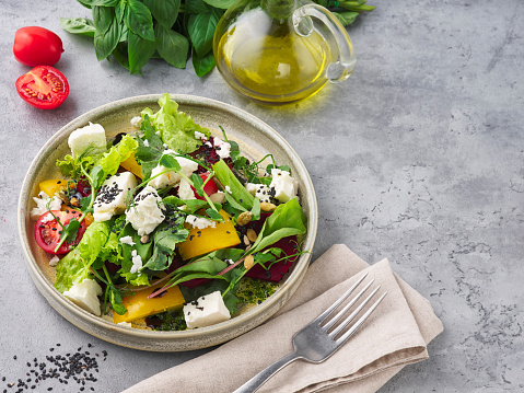 Fresh vegetable salad with feta cheese and on a stone background
