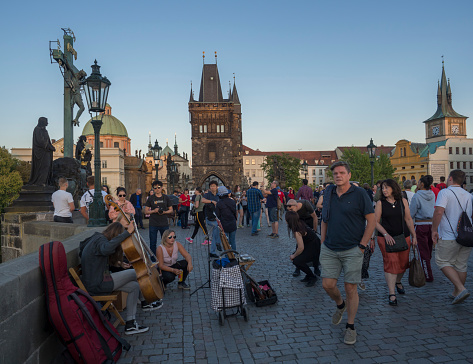 Czech Republic, Prague , September 8, 2018: View from Charles Bridge on Mala Strana Bridge Tower with walking tourist people, street artist and souvenir sellers at sunset.