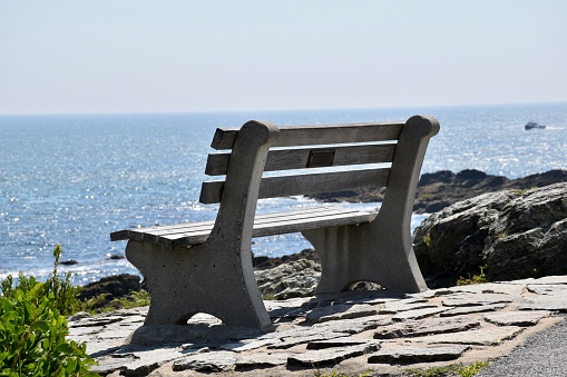 Unused bench overlooking the ocean in solitary scene