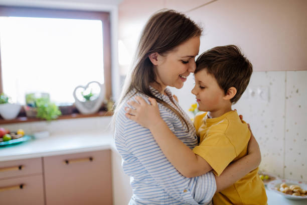 istock Happy young mother hugging her little son in kitchen at home. 1418487355