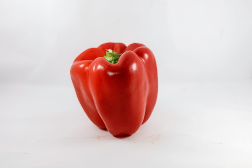 a red pepper with the green stalk cut off, pointing slightly to the left. The vegetables are in the right half of the picture. The Latin term for paprika is capsicum.