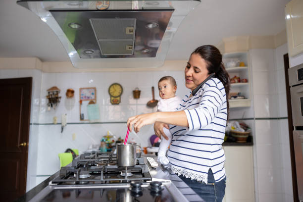istock Busy mother multi-tasking while cooking at home 1418487771
