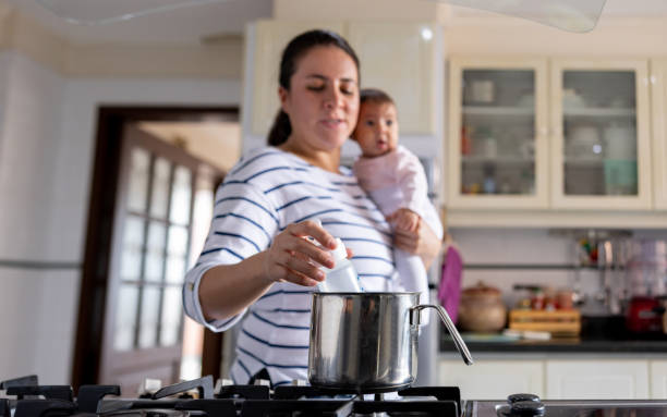 istock Mother at home heating the bottle for her baby 1418487784