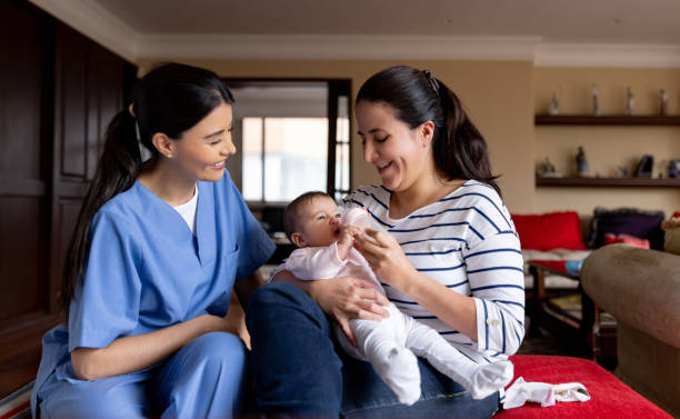 Nurse teaching a mother how to feed her baby with a bottle