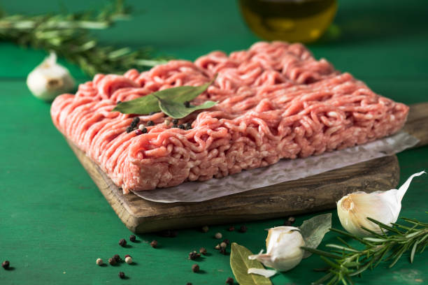 istock Raw Mince, minced Ground beef meat on a cutting board. Green background. Top view 1418488144