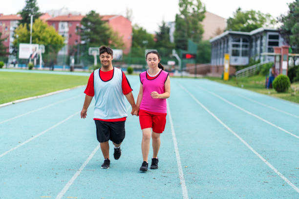 istock Young  athletes with Down syndrome running a track race 1418490375