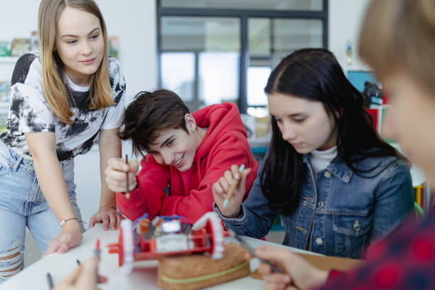 istock Group of high school students building and programming electric toys and robots at robotics classroom 1418490720