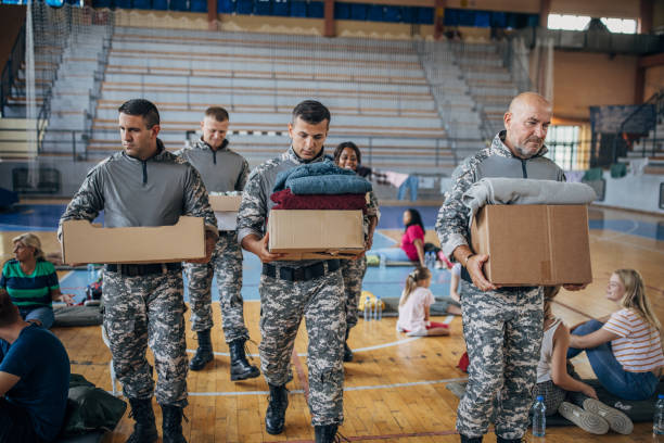 soldados carregando doações para civis - volunteer charity and relief work group of people people - fotografias e filmes do acervo