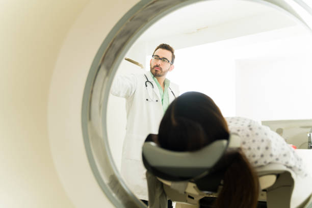 istock Rear view of a patient getting a computed tomography with a doctor 1418491098