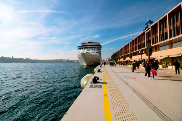 Istanbul, Turkey - August 26, 2022: Galataport , a mixed use development located along shore of Bosphorus strait, in Karakoy neighbourhood, with two large cruises docked, and pedestrians waking