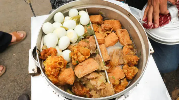 Photo of Bandung, INDONESIA - August 26, 2022: Meatballs,eggs, tofu, and dumplings that are in the pot in the Cuanki meatball cart. Meatball cuanki is one of the snacks from Bandung, West Java.