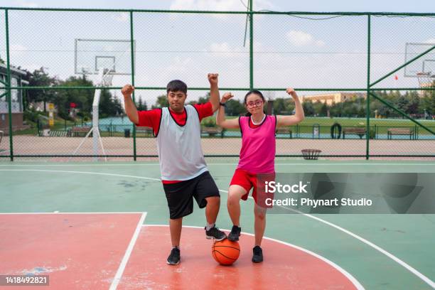 Young Couple With Down Syndrome Playing Basketball Stock Photo