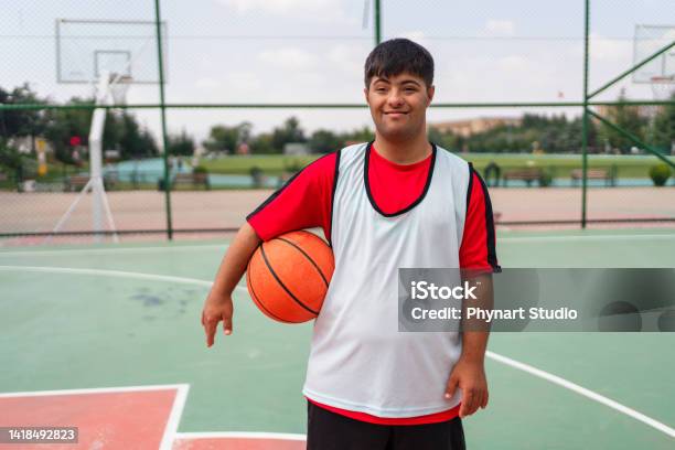 Young Man With Down Syndrome Playing Basketball Stock Photo - Download