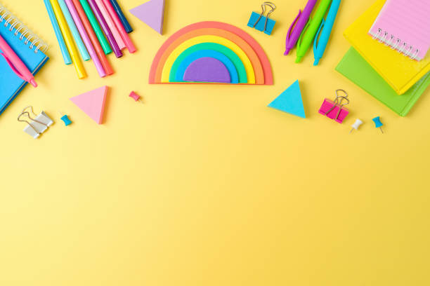 istock Back to school concept with notebooks, pens and rainbow sticky notes on yellow background. Top view, flat lay 1418492962