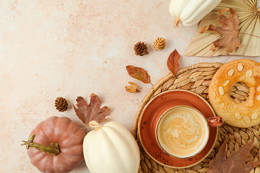 Autumn season background with coffee cup, cookie and white pumpkin on stone table. Top view, flat lay