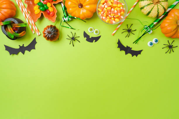 istock Halloween party concept. Pumpkin, candy and decorations on green background. Top view, flat lay 1418492977
