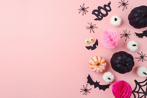Happy Halloween holiday concept. Glitter black pumpkin and party decorations on pink background. Top view, flat lay