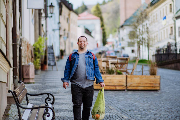 istock Independent young man with Down syndrome going back from gocery store with purchase. 1418493085