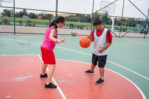 Young couple with down syndrome playing basketball