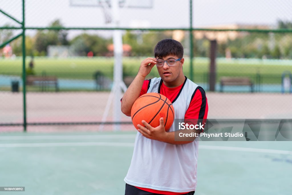Young Man With Down Syndrome Playing Basketball Stock Photo - Download