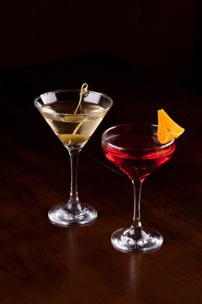 istock two cocktail glasses with martini, olive and orange on rubber stand on pub counter viewed from an angle 1418494866